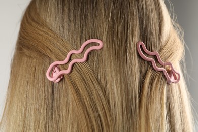 Photo of Woman with beautiful hair clips on light grey background, closeup