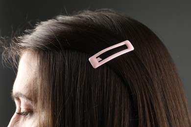 Woman with beautiful hair clip on grey background, closeup