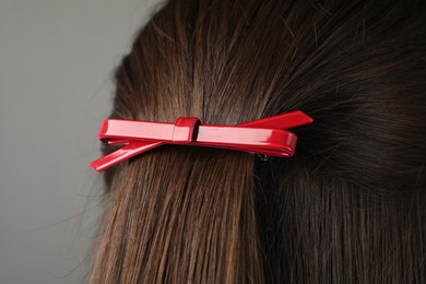 Photo of Woman with beautiful hair clip on grey background, closeup