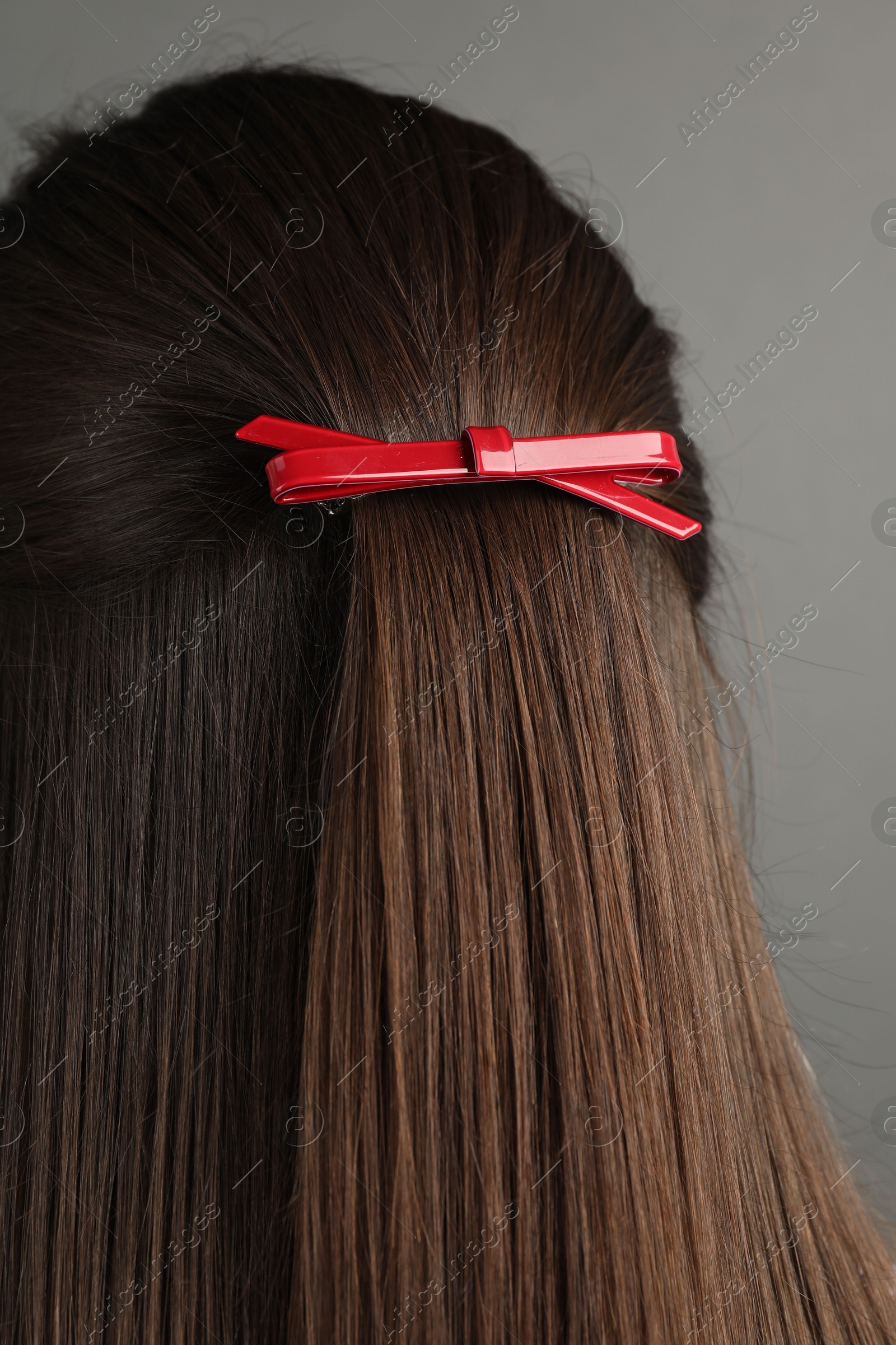 Photo of Woman with beautiful hair clip on grey background, back view