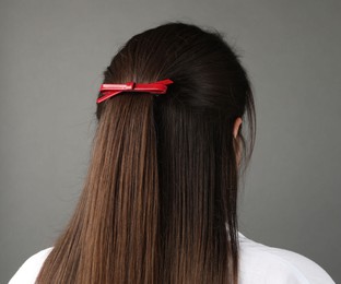 Photo of Woman with beautiful hair clip on grey background, back view