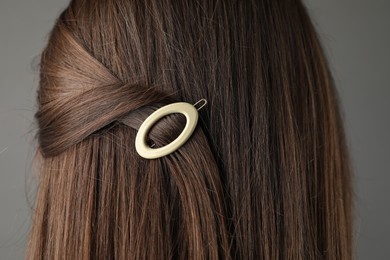 Woman with beautiful hair clip on grey background, closeup