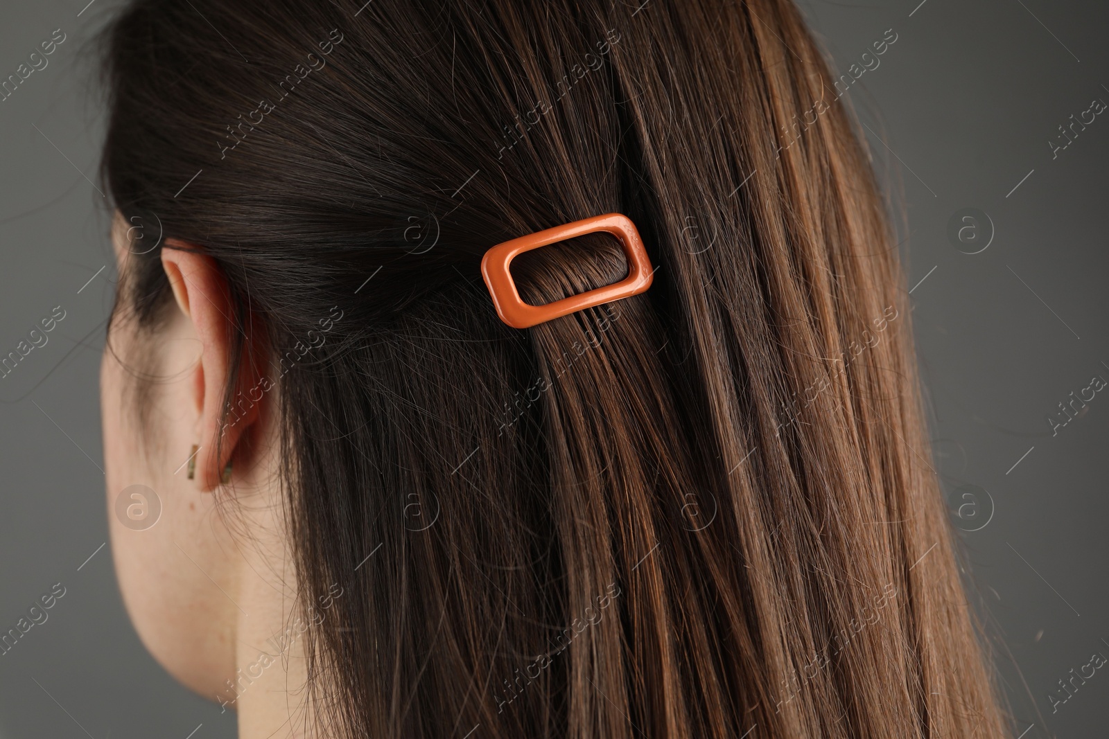 Photo of Woman with beautiful hair clip on grey background, closeup