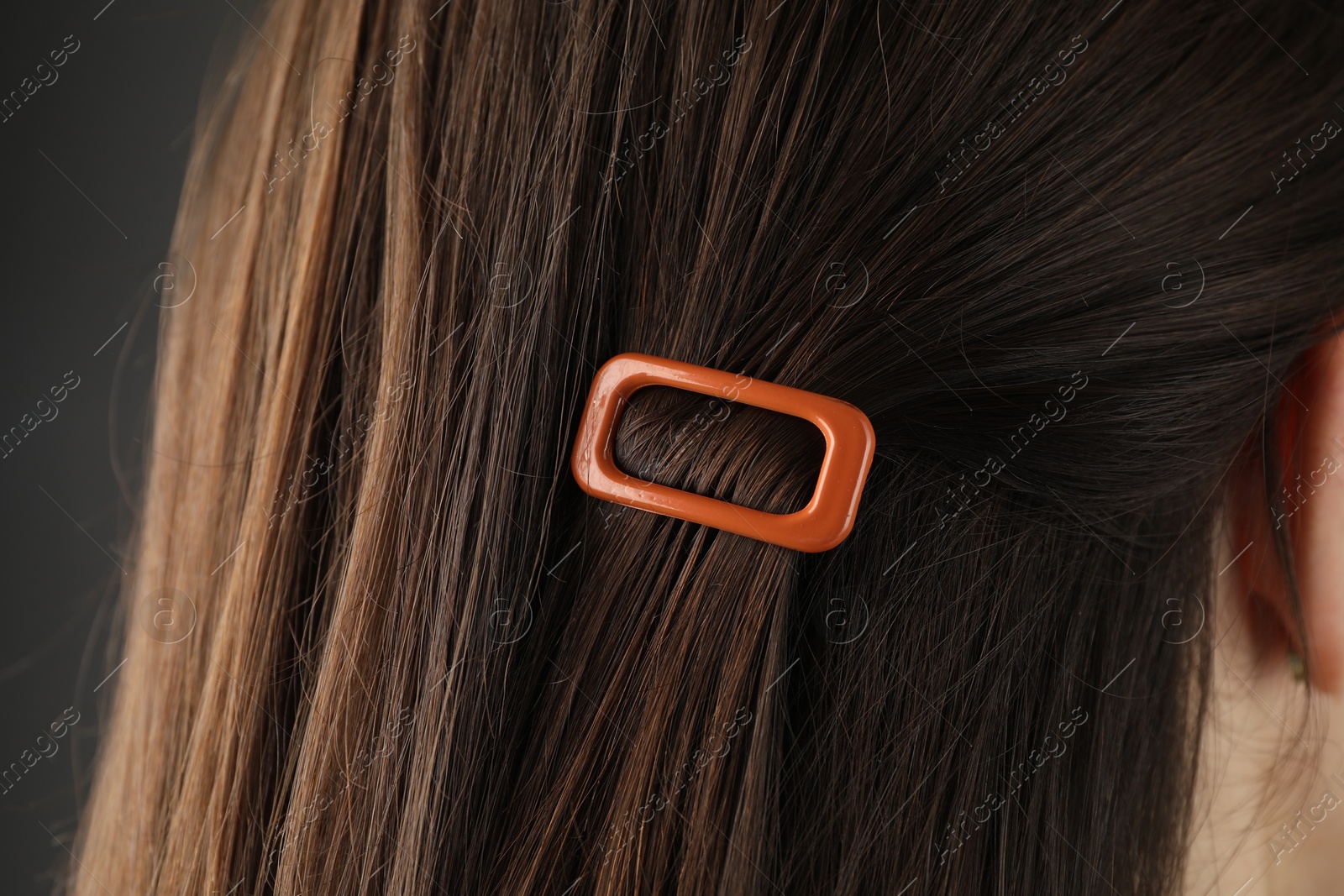 Photo of Woman with beautiful hair clip on grey background, closeup