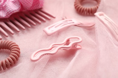 Photo of Beautiful hair accessories on pink tulle fabric, closeup