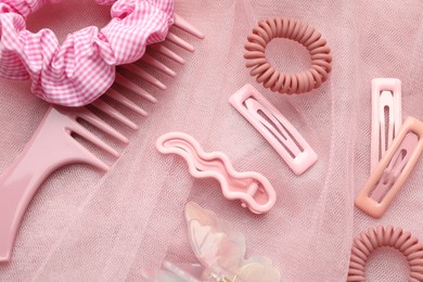 Beautiful hair accessories on pink tulle fabric, flat lay