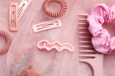 Photo of Beautiful hair accessories on pink tulle fabric, flat lay