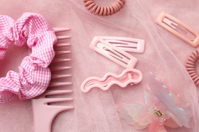 Photo of Beautiful hair accessories on pink tulle fabric, flat lay