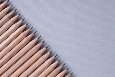 Photo of Many pencils on light grey background, top view. Space for text