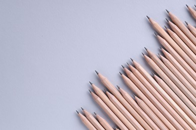 Photo of Many pencils on light grey background, top view. Space for text