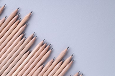 Photo of Many pencils on light grey background, top view. Space for text