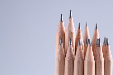 Many pencils on light grey background, closeup. Space for text