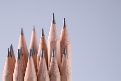 Many pencils on light grey background, closeup. Space for text