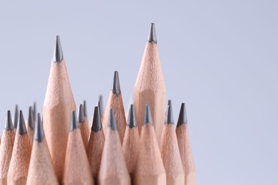 Many pencils on light grey background, closeup