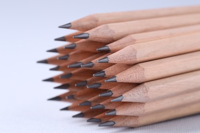 Many pencils on light grey background, closeup