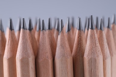 Many pencils on light grey background, closeup