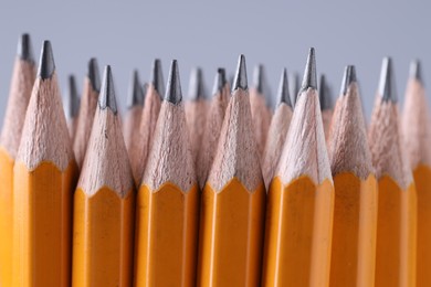 Many pencils on light grey background, closeup