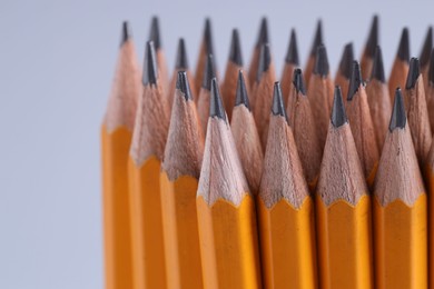 Many pencils on light grey background, closeup