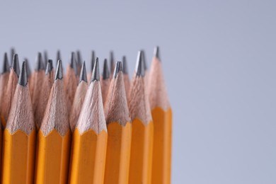 Photo of Many pencils on light grey background, closeup