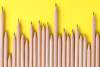 Photo of Many pencils on yellow background, top view