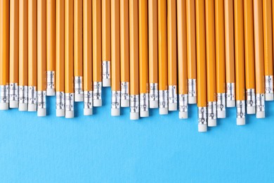 Photo of Many pencils on light blue background, top view