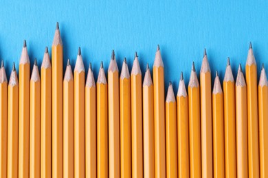 Photo of Many pencils on light blue background, top view