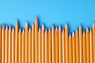 Photo of Many pencils on light blue background, top view