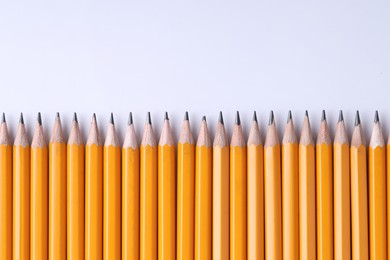 Photo of Many pencils on light grey background, top view. Space for text