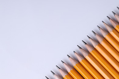 Photo of Many pencils on light grey background, top view. Space for text