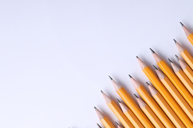 Photo of Many pencils on light grey background, top view. Space for text