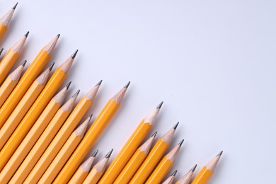 Photo of Many pencils on light grey background, top view. Space for text