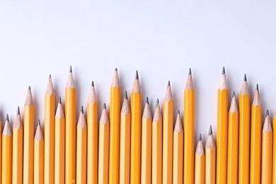 Photo of Many pencils on light grey background, top view. Space for text