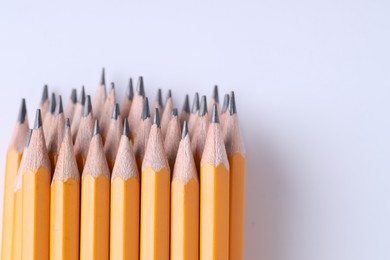 Photo of Many pencils on light grey background, closeup. Space for text