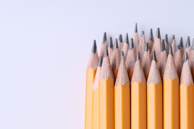 Photo of Many pencils on light grey background, closeup. Space for text