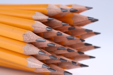 Many pencils on light grey background, closeup