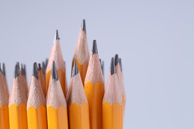 Photo of Many pencils on light grey background, closeup. Space for text