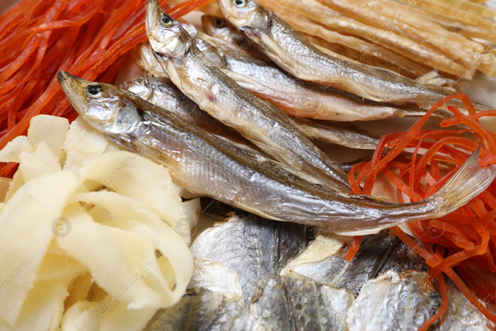 Photo of Many different dried fish snacks on table, closeup