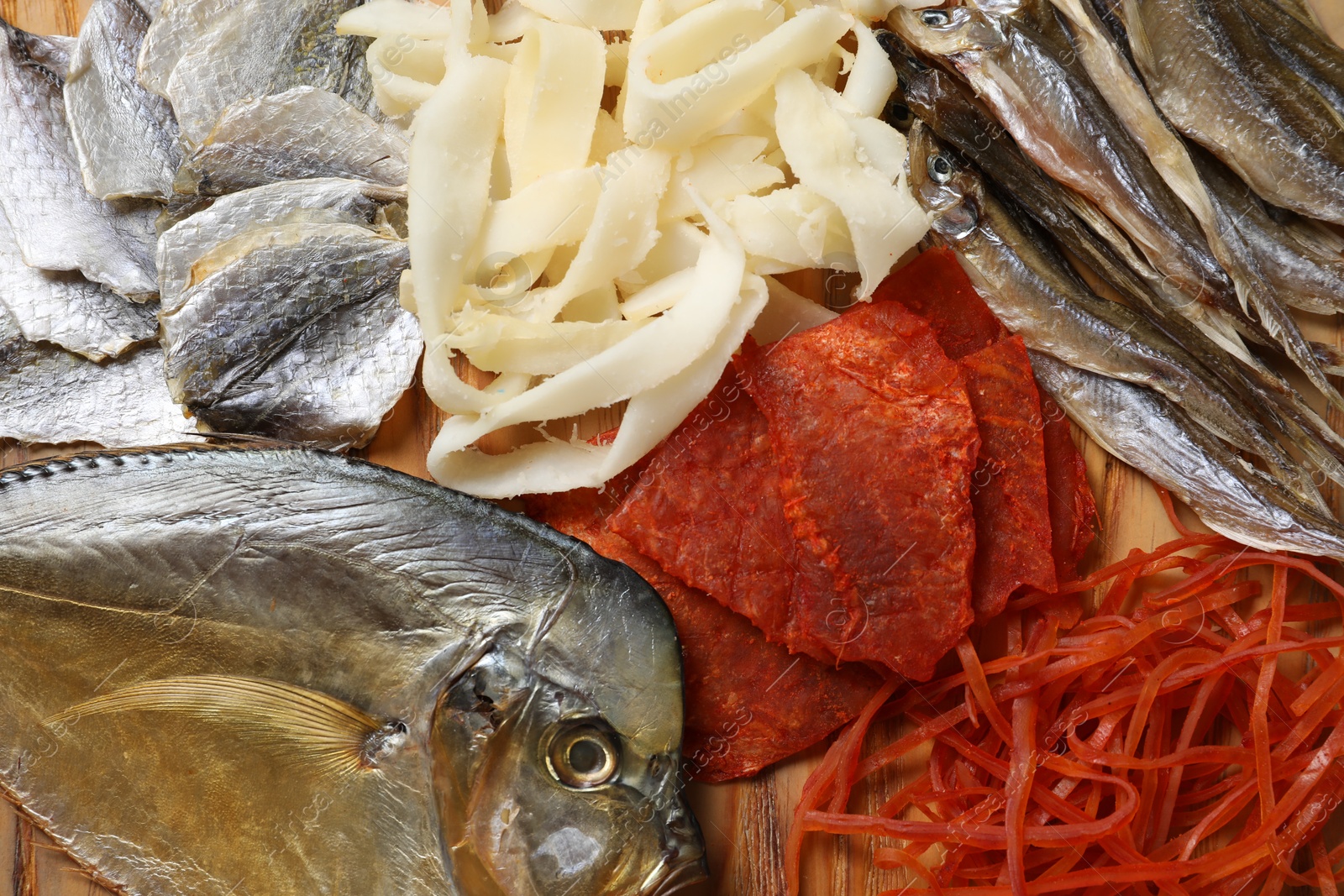 Photo of Many different dried fish snacks on table, closeup