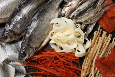 Photo of Many different dried fish snacks on table, closeup