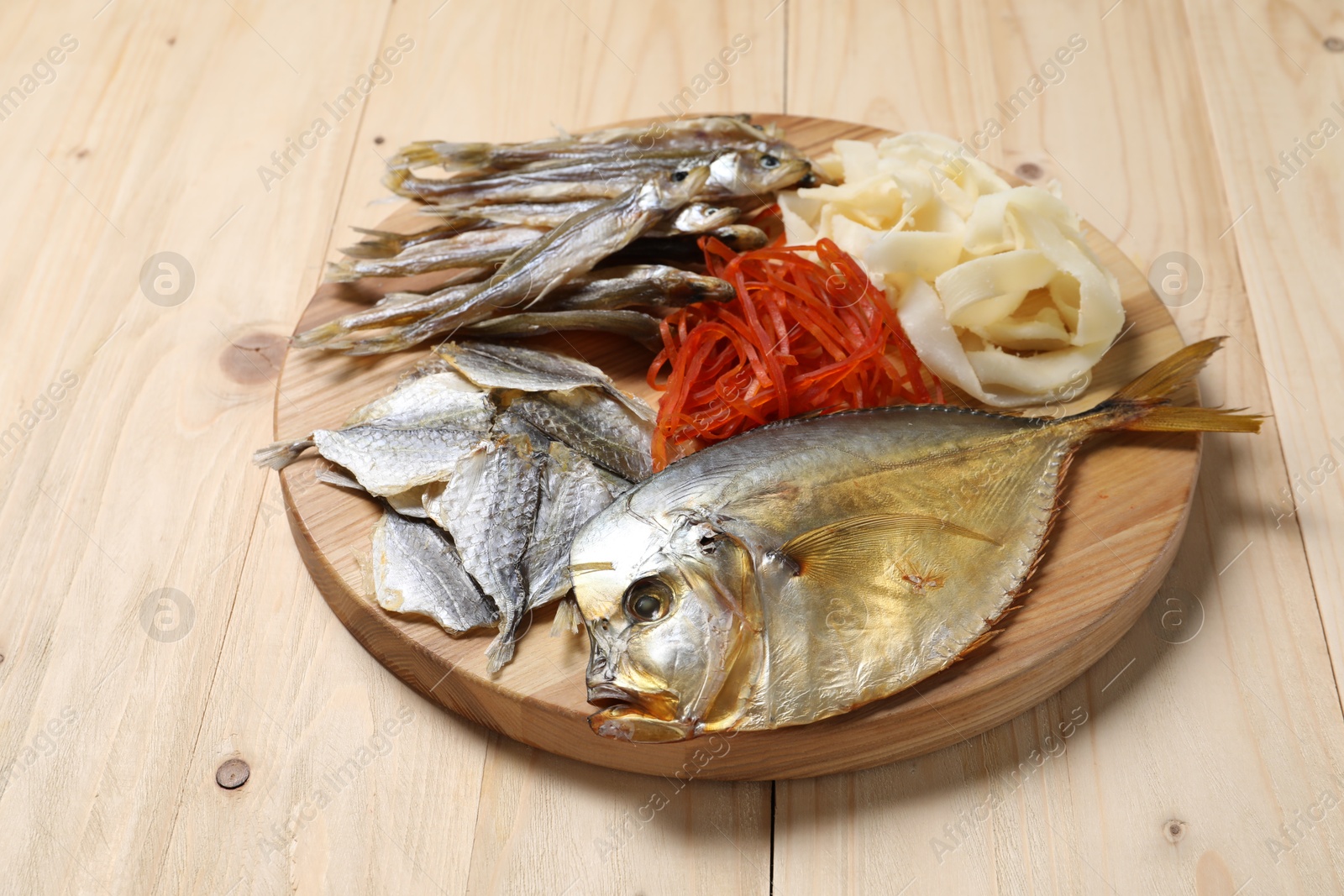 Photo of Many different dried fish snacks on wooden table