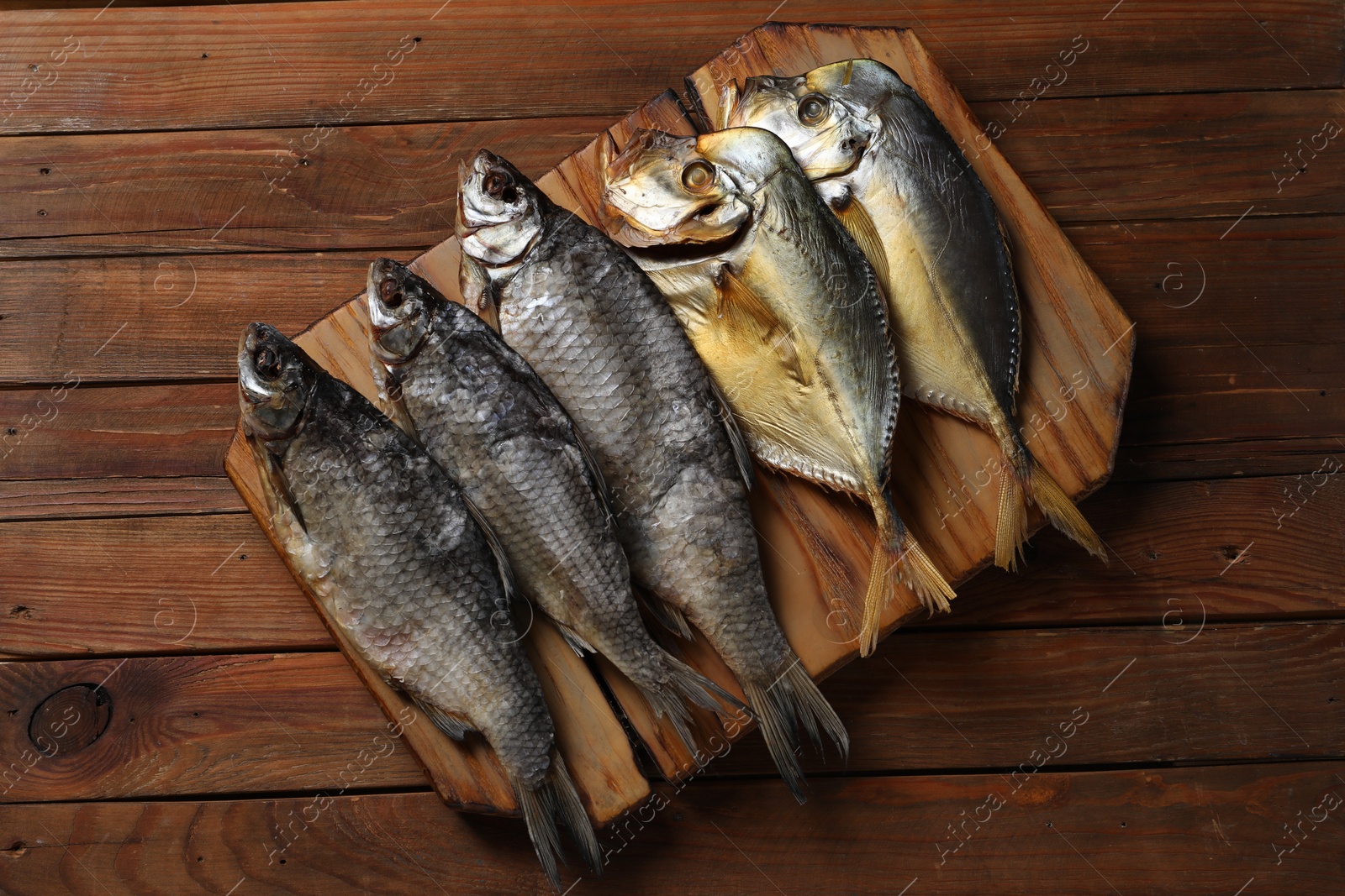 Photo of Many different dried fish on wooden table, top view