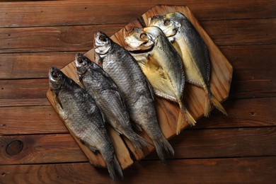 Many different dried fish on wooden table, top view