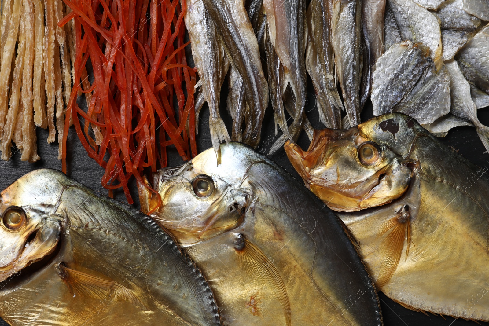 Photo of Many different dried fish snacks on table, closeup