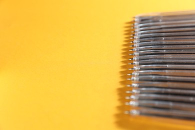 Photo of Many ballpoint pens on orange background, closeup. Space for text