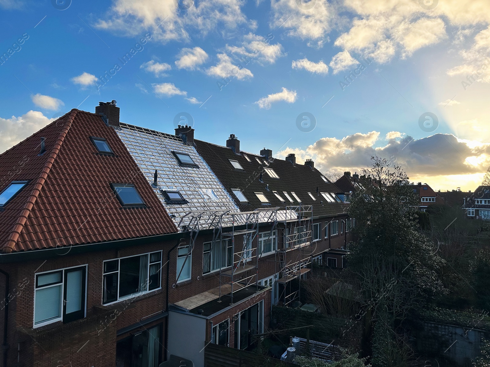 Residential building with roof renovation under blue sky Photo of Residential building with roof renovation under blue sky