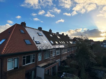 Photo of Residential building with roof renovation under blue sky