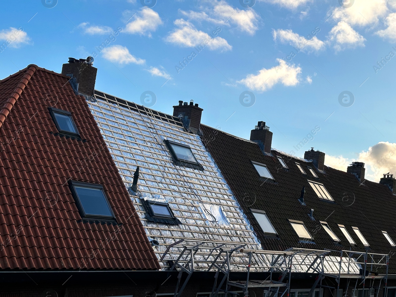 Residential building with roof renovation under blue sky Photo of Residential building with roof renovation under blue sky