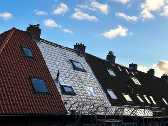 Photo of Residential building with roof renovation under blue sky
