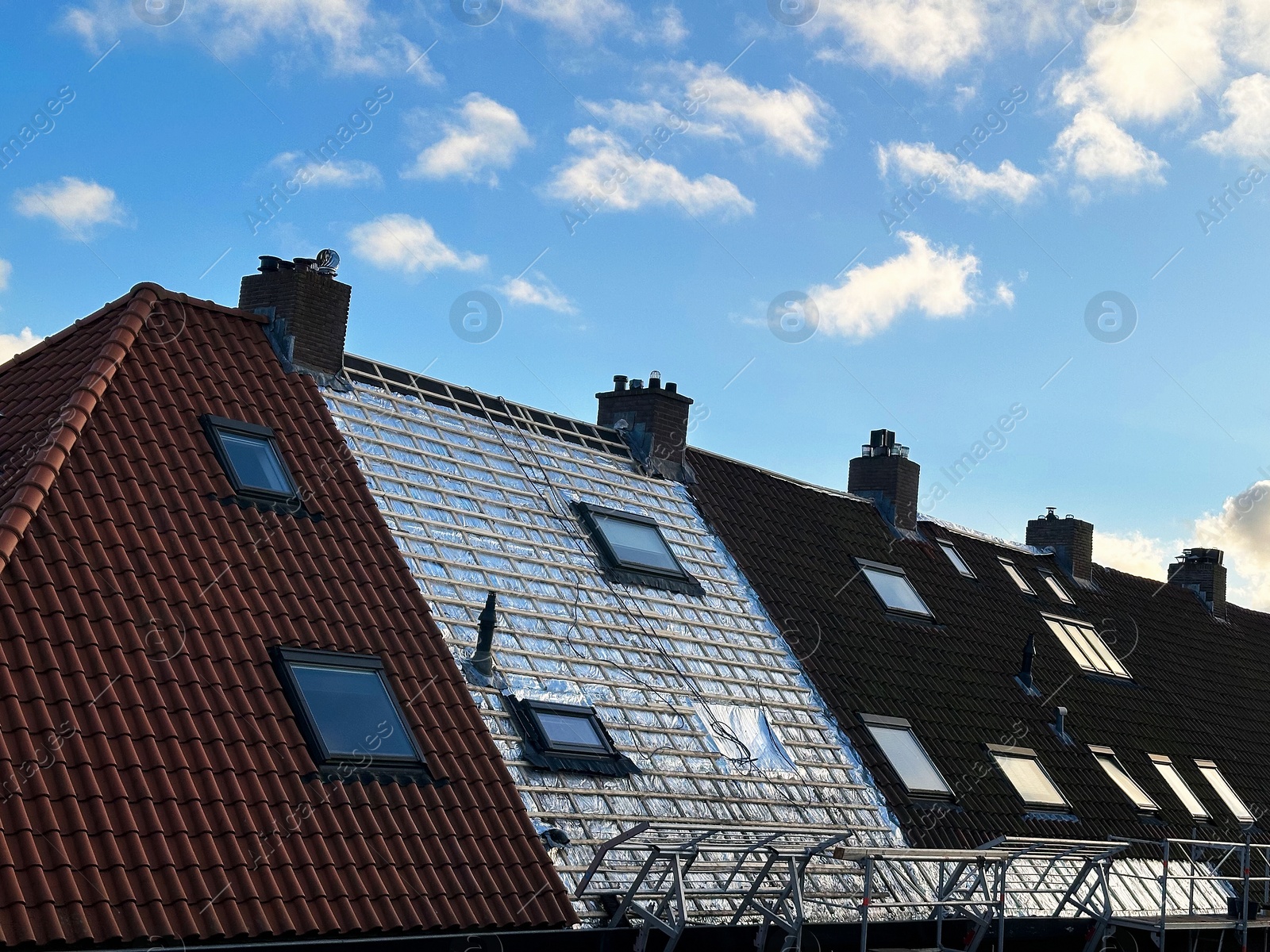 Residential building with roof renovation under blue sky Photo of Residential building with roof renovation under blue sky