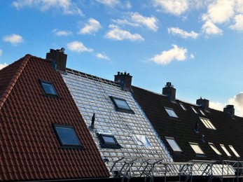 Photo of Residential building with roof renovation under blue sky